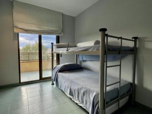 埃斯塔蒂特La Pineda I 1 3-6的一间卧室设有两张双层床和一扇窗户。