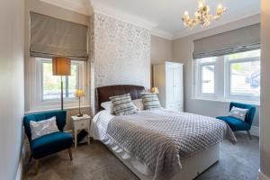 兰迪德诺赛夫顿庭院酒店的一间卧室配有一张床和两张蓝色椅子