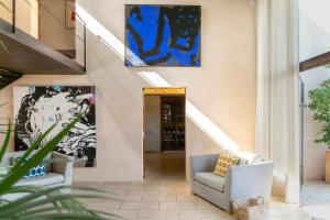 波托尔Premier Villa Rental in Mallorca Es Barranc Vell的走廊上设有两把椅子和墙上的绘画