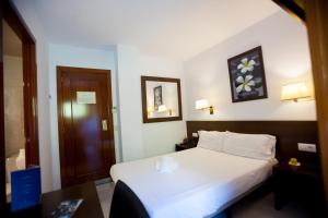 安道尔城Insitu Eurotel Andorra的一间设有白色床和木门的酒店客房