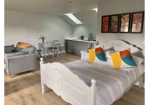 Great OuseburnAcorn Attic, a modern, new first floor garden annex的卧室内的白色床和色彩缤纷的枕头