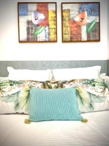 罗塔MyChoice Dadim by Bossh! Apartments的一张带两张照片的床,上面有蓝色的枕头