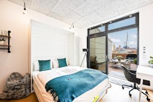 曼海姆Lit Living - Luxus Loft - Box Spring - Air Con - BBQ - Panorama的一间卧室配有一张床、一张书桌和一个窗户。