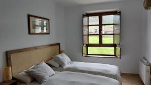 NoriegaPreciosa Casa de Indiano En Noriega (Asturias)的一间卧室设有两张床和窗户。