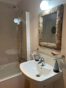 NoriegaPreciosa Casa de Indiano En Noriega (Asturias)的浴室配有盥洗盆、镜子和浴缸