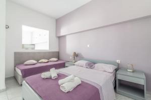 莫拉托斯Akali Apt Next to the Beach的紫白色客房的两张床