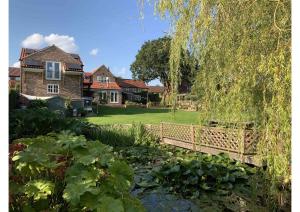 Great OuseburnAcorn Attic, a modern, new first floor garden annex的一座桥,在一座房子前面的池塘上