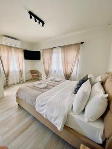斯基亚索斯镇Olea White的卧室配有一张带白色床单和枕头的大床。
