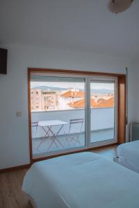 卡米尼亚Arca Nova Guest House & Hostel Caminha的一间卧室设有美景大窗户