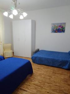 蒙特圣萨维诺dalla CARLA in Toscana的一间卧室配有两张蓝色的床和椅子