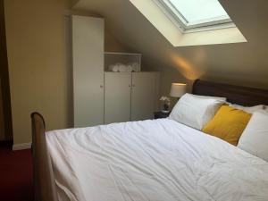 克利夫登Railway Avenue Rooms的一间卧室配有一张带天窗的大床