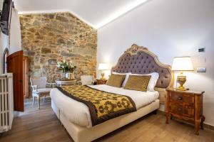毕威格利亚努Residenza le Colline del Paradiso的一间卧室设有一张大床和石墙