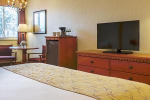 西雅茅斯碧沙度假酒店的一间卧室配有一张床,梳妆台上配有电视