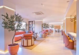 贝纳尔马德纳日落海滩俱乐部公寓酒店的大堂配有沙发、椅子和一棵树