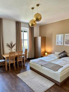 多瑙河畔的马尔巴赫Johnys Jungle的卧室配有一张床和一张桌子及椅子