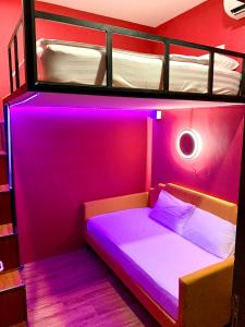 新加坡Arena eSports Hotel @ Bugis Village的一间卧室配有一张双层床,拥有紫色的灯光