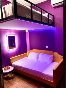 新加坡Arena eSports Hotel @ Bugis Village的一间卧室设有紫色的房间,配有一张双层床