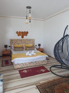 丹吉尔villaluna的一间卧室配有一张特大号床和一把椅子