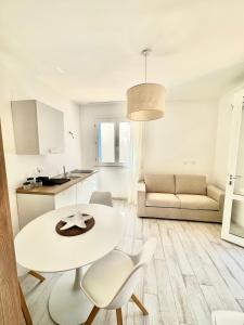 马里迪莫Bilocale Vista Mare的白色的厨房以及带桌椅的客厅。
