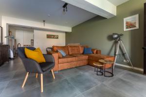 NeerpeltDe Hoog Velden 11的客厅配有棕色沙发和黄色枕头