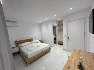 萨兰达Sea Breeze Villa的白色卧室配有床和木桌