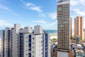 大普拉亚Aptos na PG em excelente localização à 100m da PRAIA no Centro da Cidade com Garagem, Ar Condicionado, Portaria 24H的享有城市高楼和大海的景致