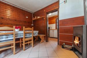 GoreljekMala koča Wooden Cabin的客房设有壁炉、桌子和炉灶。