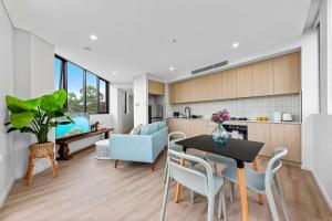 悉尼Elegant and Modern Style Apartments in Dulwich hill的厨房以及带桌椅的起居室。