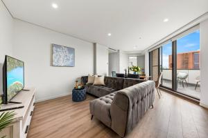 悉尼Elegant and Modern Style Apartments in Dulwich hill的带沙发和大窗户的客厅