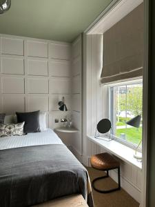 海伦斯堡Rooms Above Sugar Boat的一间卧室设有一张床、一个窗口和一把椅子