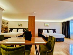 阿姆斯特丹Chassé Hotel Residency的酒店客房带两张床和一张桌子以及椅子。