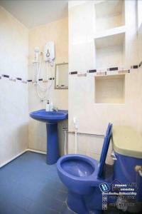 丹绒武雅Cozy 6BR Gurney GeorgeTown Homestay的浴室设有蓝色的卫生间和水槽。