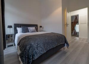 卢森堡EXECUTIVE DOUBLE ROOM WITH EN-SUITE in GUEST HOUSE RUE TREVIRES R3的一间卧室配有一张大床和黑色毯子