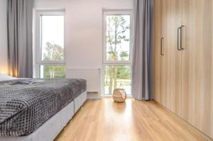 梅尔诺Domki - Villa Buena Vista - Mielno的一间卧室设有一张床和两个窗户。