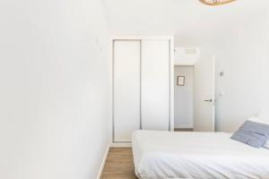阿桂拉斯Luxury Designer Apartment - Unbeatable Sea Views的白色卧室设有白色墙壁和床