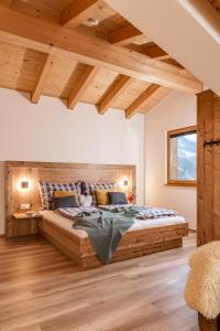 斯拉德明Piekvier lodge的一间带一张大型木床的卧室,位于带木制天花板的房间内