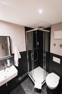 费尔巴赫City Hotel Fellbach 24H CHECK-IN的带淋浴、卫生间和盥洗盆的浴室