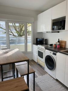 基扬古尔Appartement SQY的厨房配有洗衣机和桌子