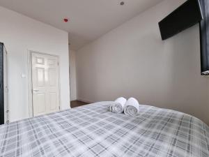 利物浦Portside Liverpool的一间卧室配有一张带2双白色拖鞋的床。