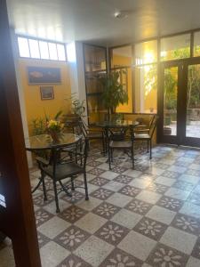 瓦拉斯La Casa de Zarela的一间铺有瓷砖地板并配有桌椅的用餐室