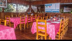 CuyavenusCaiman Lodge的餐厅配有桌椅和粉红色的桌布