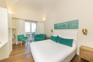 卡普里Casa Dani Capri的一间卧室配有一张床和两张绿色椅子