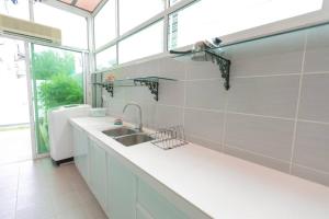 卧佛Teluk Bahang European Style SemiD 4 Bedrooms 10ppl的白色的厨房设有水槽和窗户
