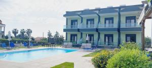 尼基季Paramithi Luxury Apartments的一座大建筑,旁边是一座房子,设有游泳池