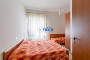 利多迪耶索罗Condominio Baraziol的一间卧室配有一张带彩色毯子的床