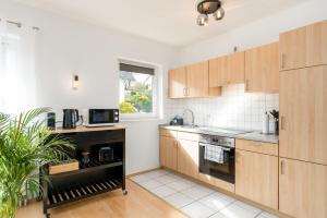埃德湖Harmony: Edersee Apartment – Sperrmauer – Lounge的厨房配有木制橱柜和窗户。