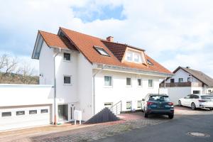 埃德湖Harmony: Edersee Apartment – Sperrmauer – Lounge的白色房子,有红色屋顶