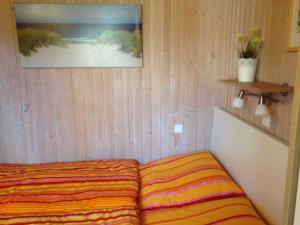 格吕克斯堡Ferienwohnung Michel的一张床上,床上有条纹毯子