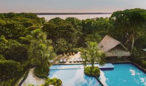莱蒂西亚Biohotel Arara River的享有度假村的空中景致,设有游泳池和树木