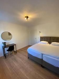 路德维希堡Nisay Home - 4 Room Apartment - Nr2的一间卧室配有一张床、一张书桌和一面镜子